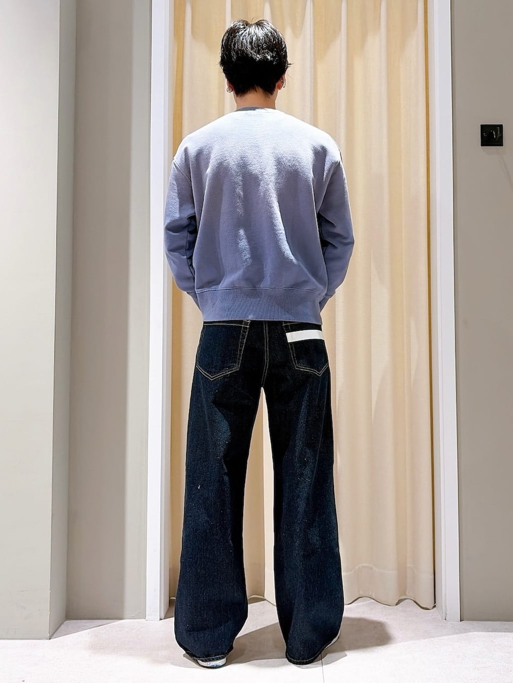 グレー系のスニーカー、ブルー系のデニムパンツ、ブルー系のスウェットを着用したメンズの春コーディネートの3枚目の写真