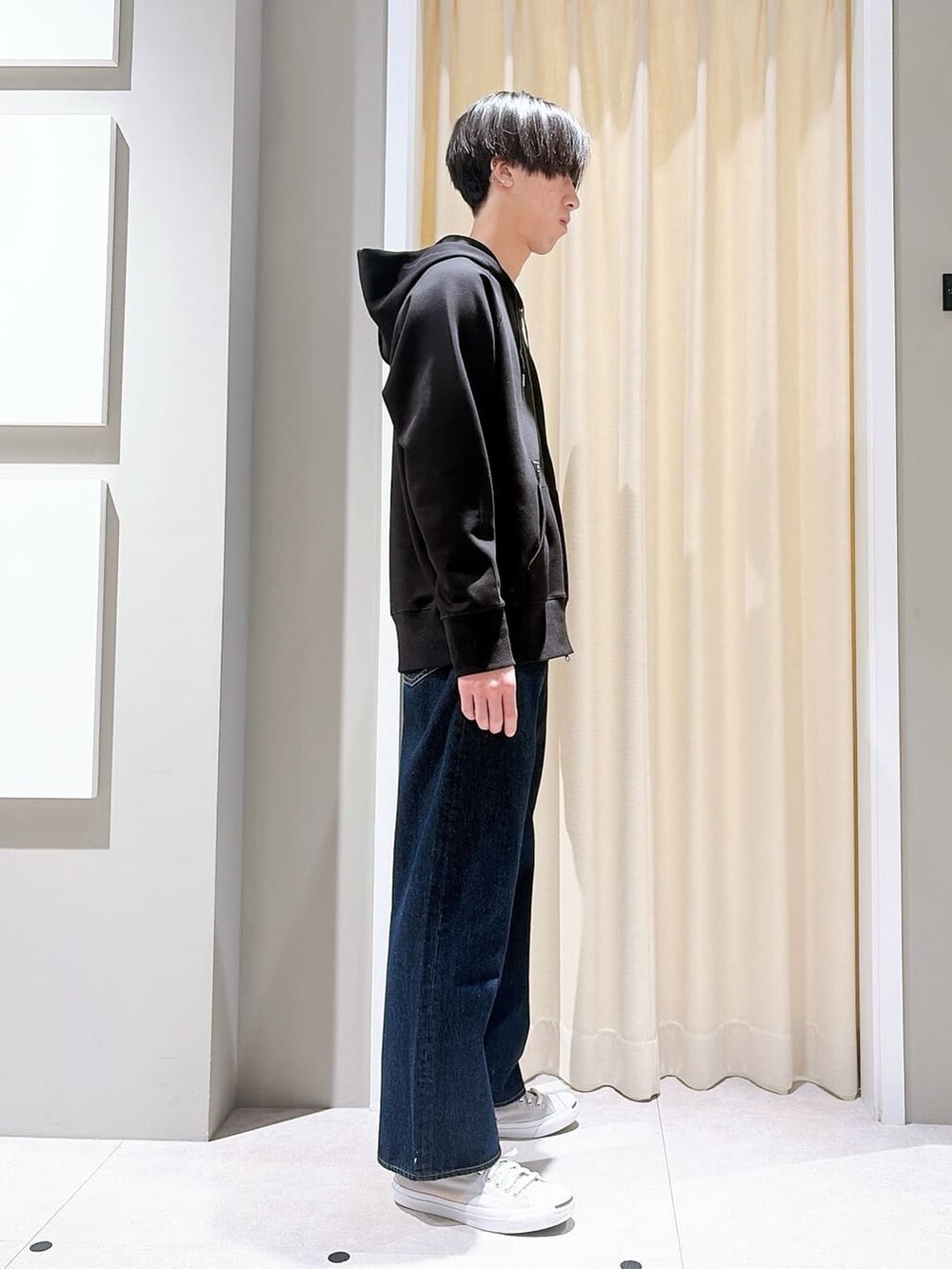 グレー系のスニーカー、ブルー系のその他パンツ、ブラック系のパーカーを着用したメンズの秋コーディネートの4枚目の写真