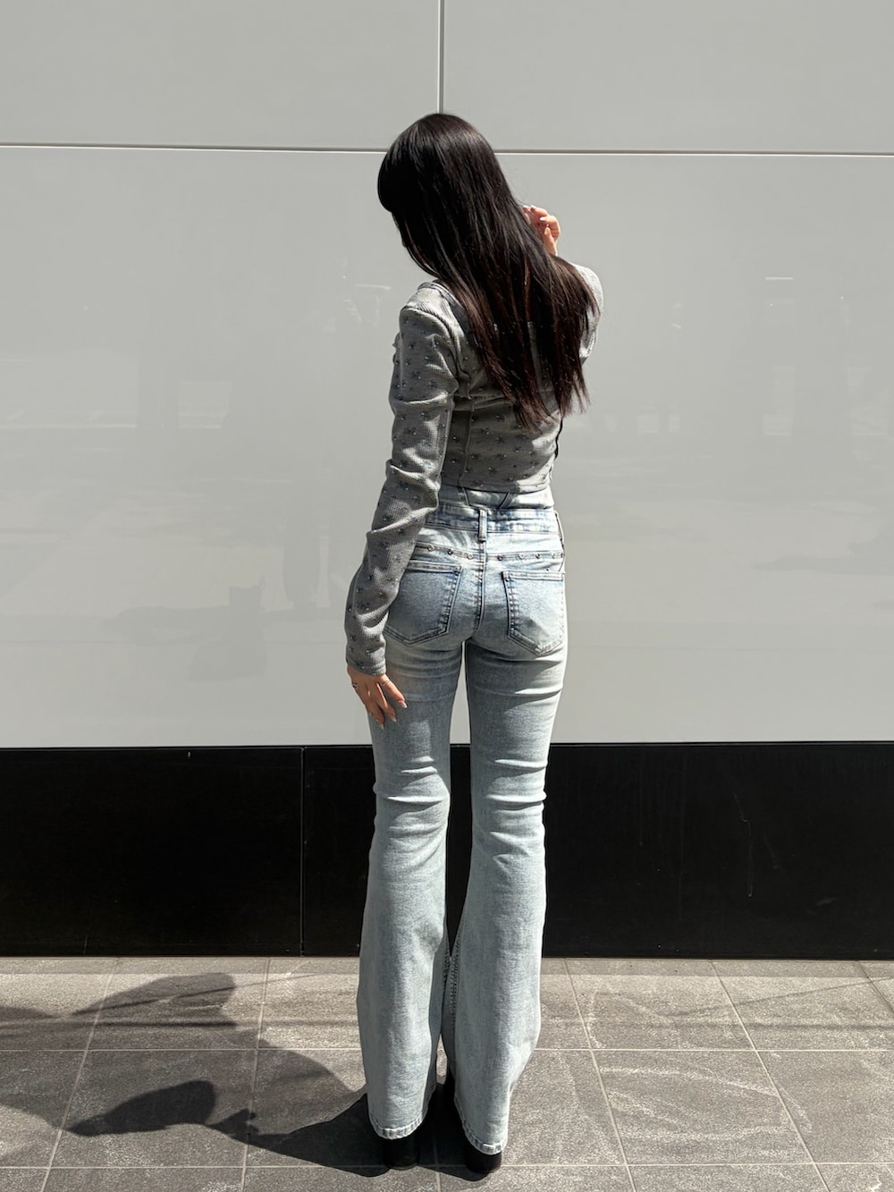 グレー系のTシャツ/カットソー、ブルー系のデニムパンツ、ブラック系のサンダルを着用したレディースの春コーディネートの3枚目の写真