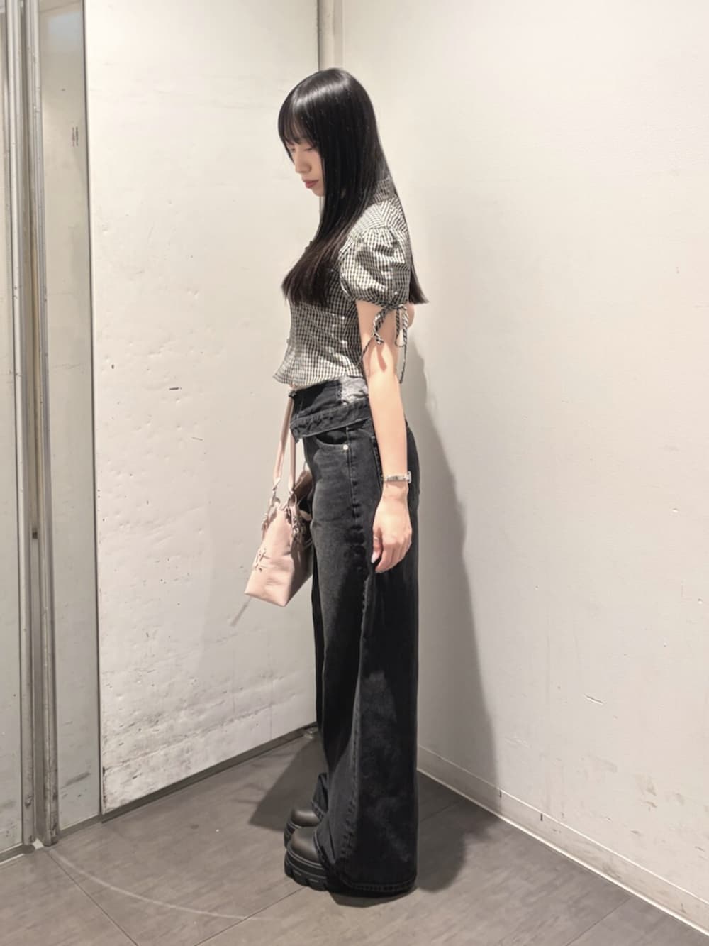 ブラック系のブーツ、ピンク系のショルダーバッグ、ブラック系のTシャツ/カットソーを着用したレディースの秋コーディネートの2枚目の写真