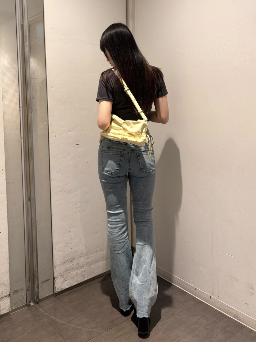 ブラック系のサンダル、グレー系のTシャツ/カットソー、イエロー系のハンドバッグを着用したレディースの春コーディネートの3枚目の写真