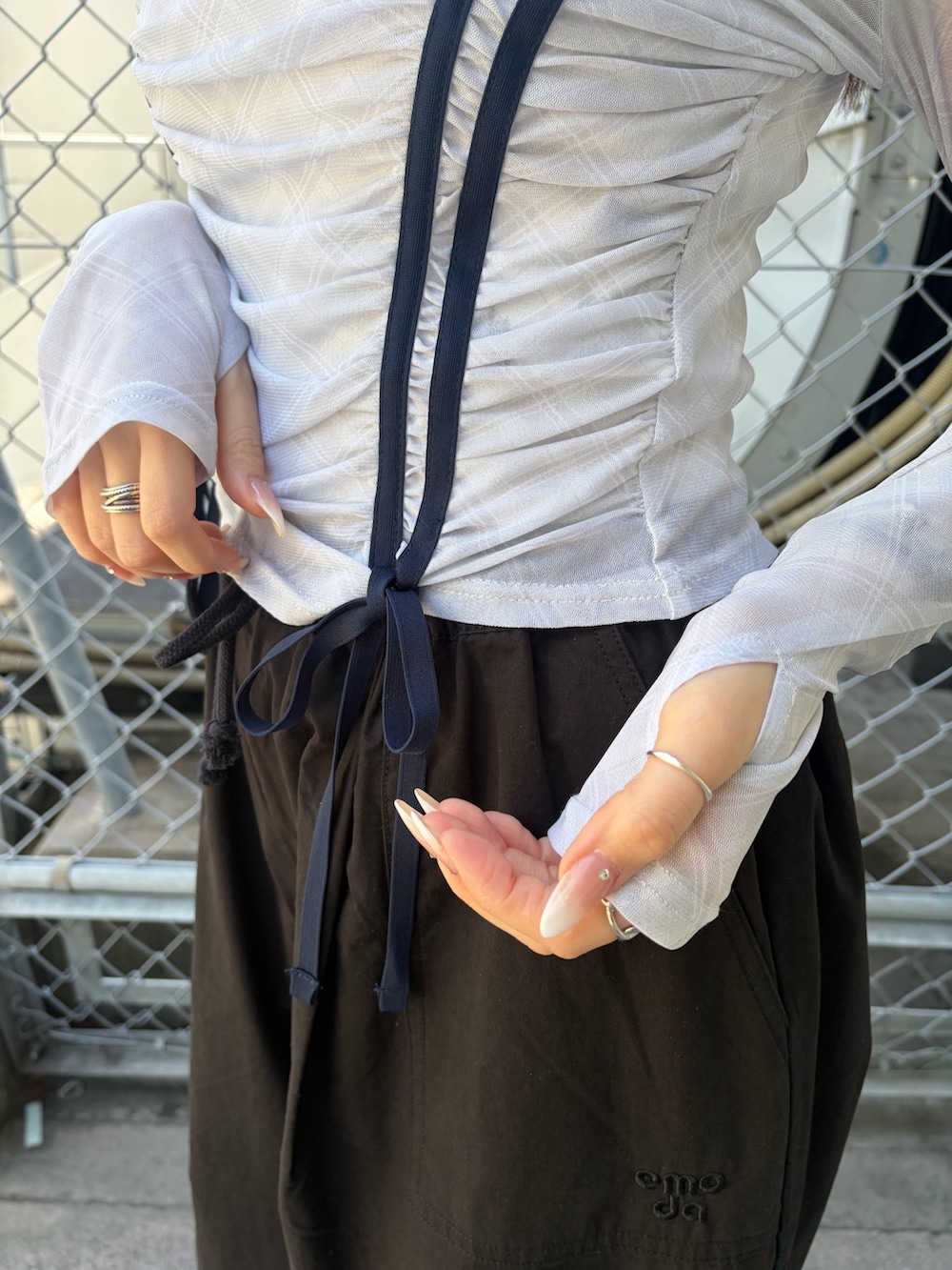 ブラック系のその他パンツ、ホワイト系のTシャツ/カットソー、ブラック系のブーツを着用したレディースの春コーディネートの6枚目の写真