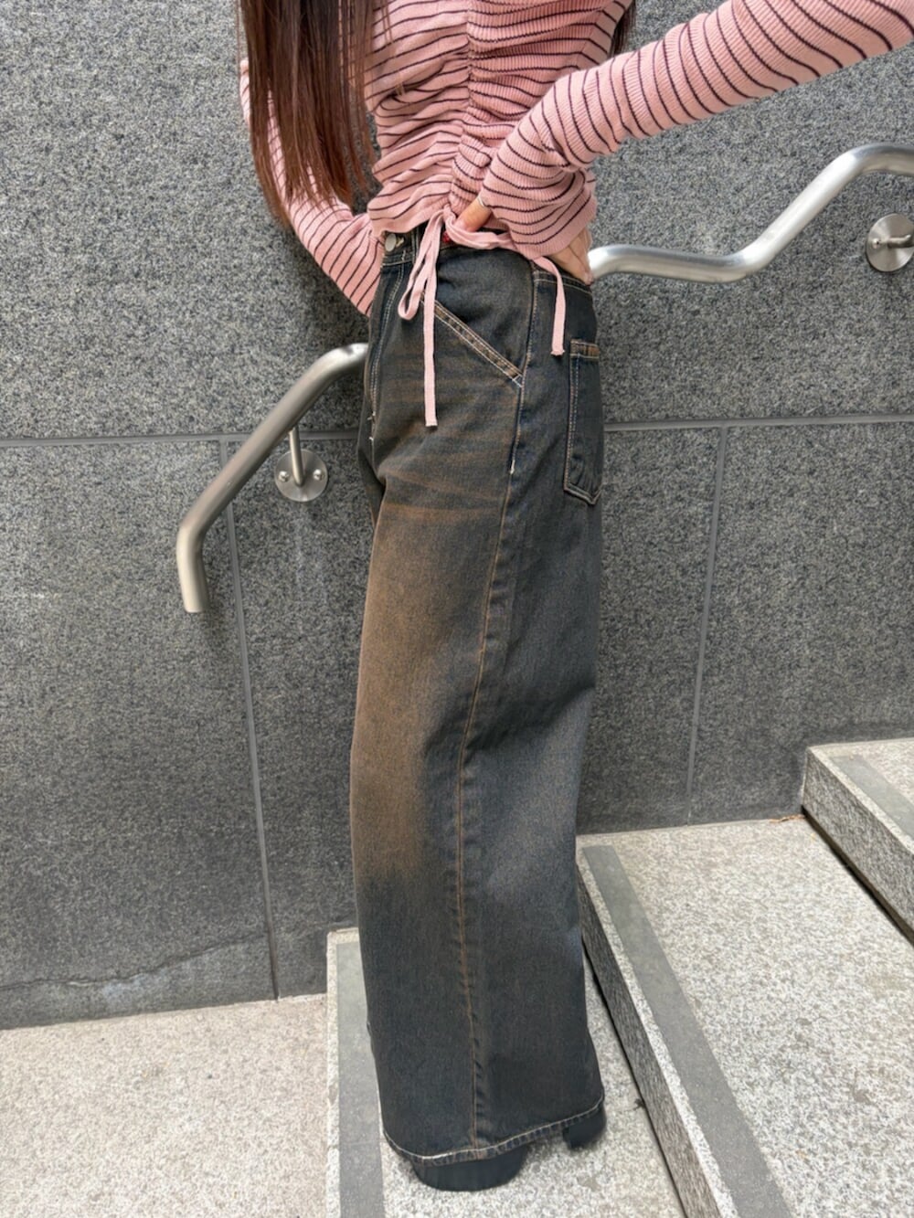 ブラック系のブーツ、ブルー系のデニムパンツ、ピンク系のニット/セーターを着用したレディースの冬コーディネートの9枚目の写真