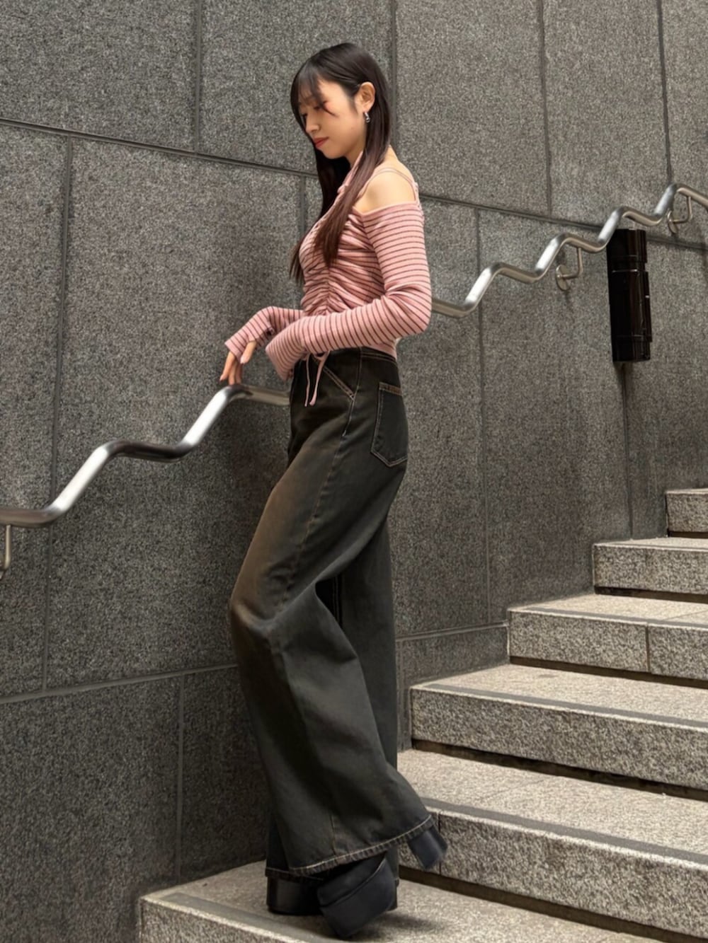 ブラック系のブーツ、ブルー系のデニムパンツ、ピンク系のニット/セーターを着用したレディースの冬コーディネートの2枚目の写真