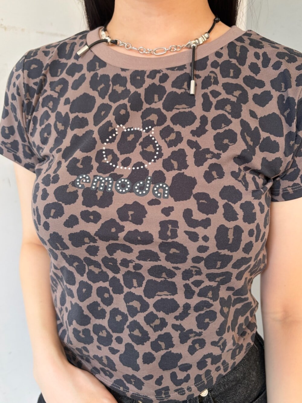 ブラウン系のTシャツ/カットソー、ブラック系のスカート、ブラック系のブーツを着用したレディースの夏コーディネートの4枚目の写真