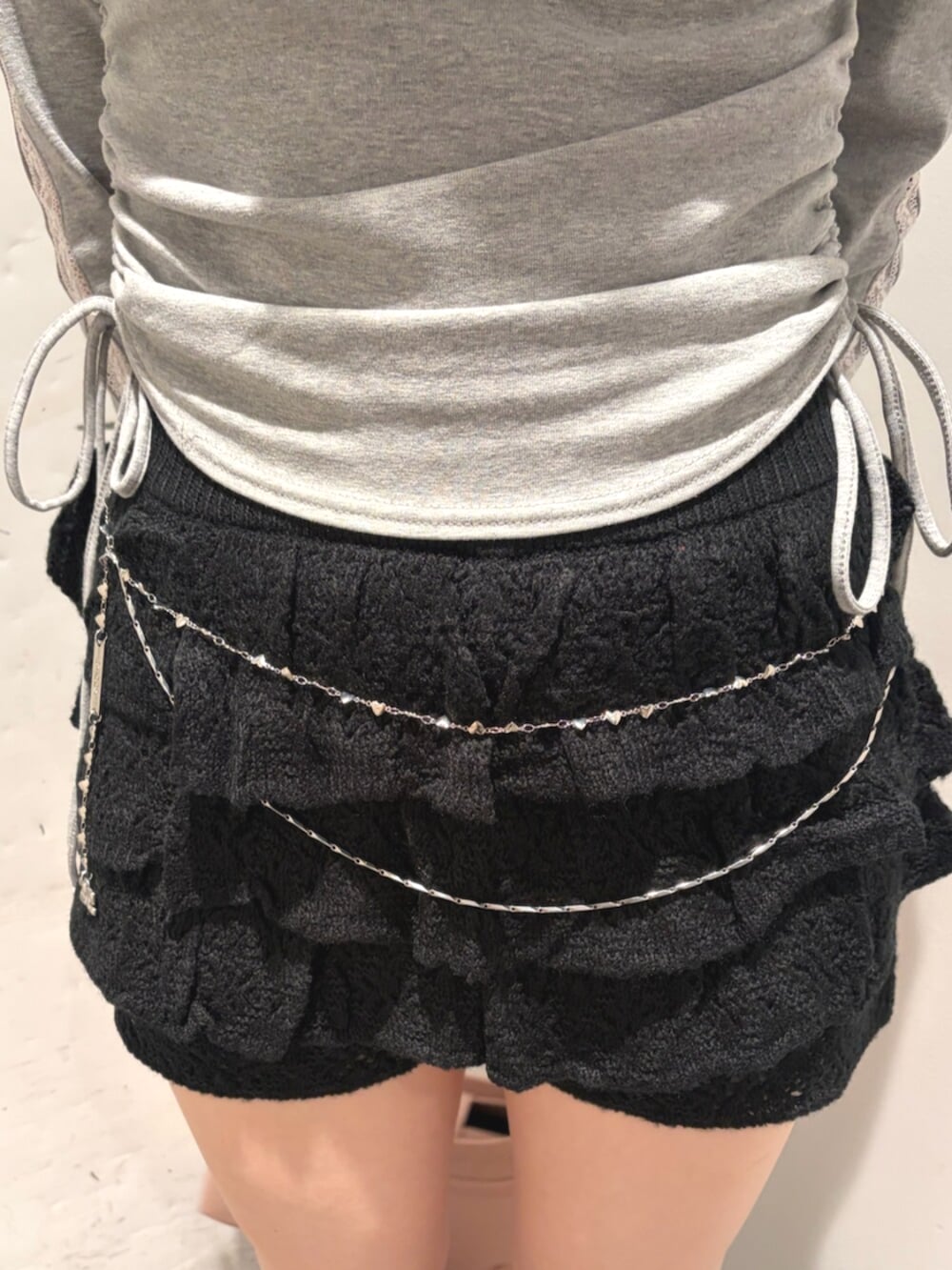 ブラック系のブーツ、グレー系のTシャツ/カットソー、ブラック系のスカートを着用したレディースの夏コーディネートの7枚目の写真