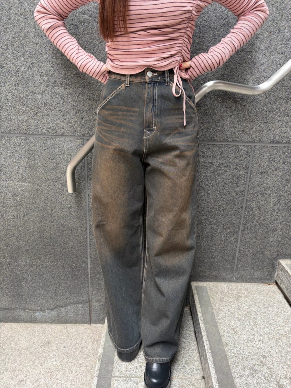 ブラック系のブーツ、ブルー系のデニムパンツ、ピンク系のニット/セーターを着用したレディースの冬コーディネートの8枚目の写真