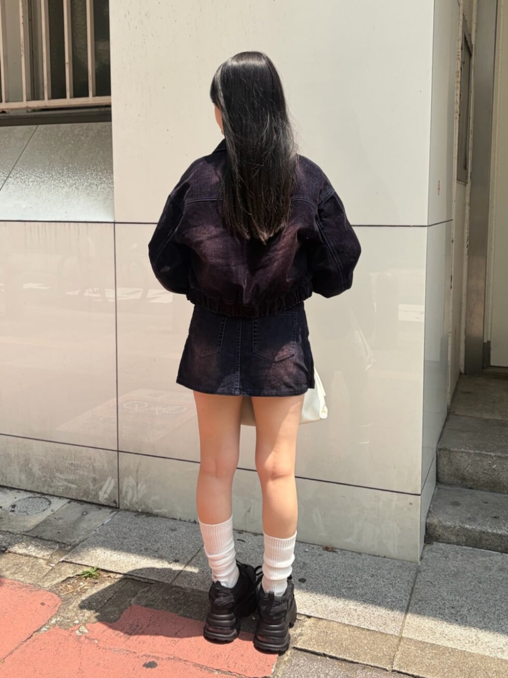 ホワイト系のキャミソール、ブラック系のスニーカー、ブルー系のブルゾンを着用したレディースの夏コーディネートの3枚目の写真