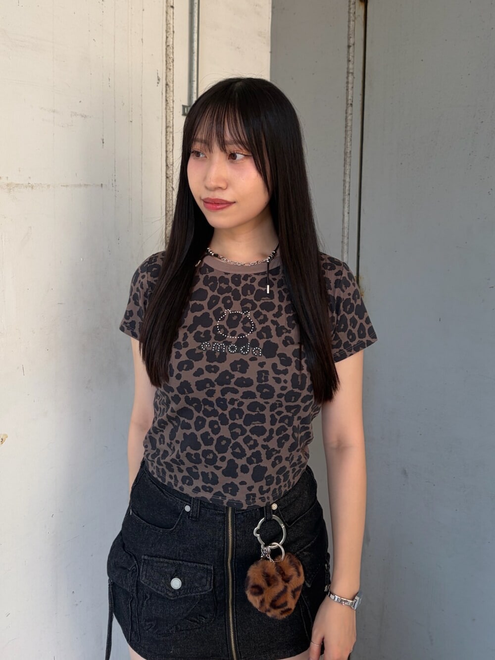 ブラウン系のTシャツ/カットソー、ブラック系のスカート、ブラック系のブーツを着用したレディースの夏コーディネートの3枚目の写真
