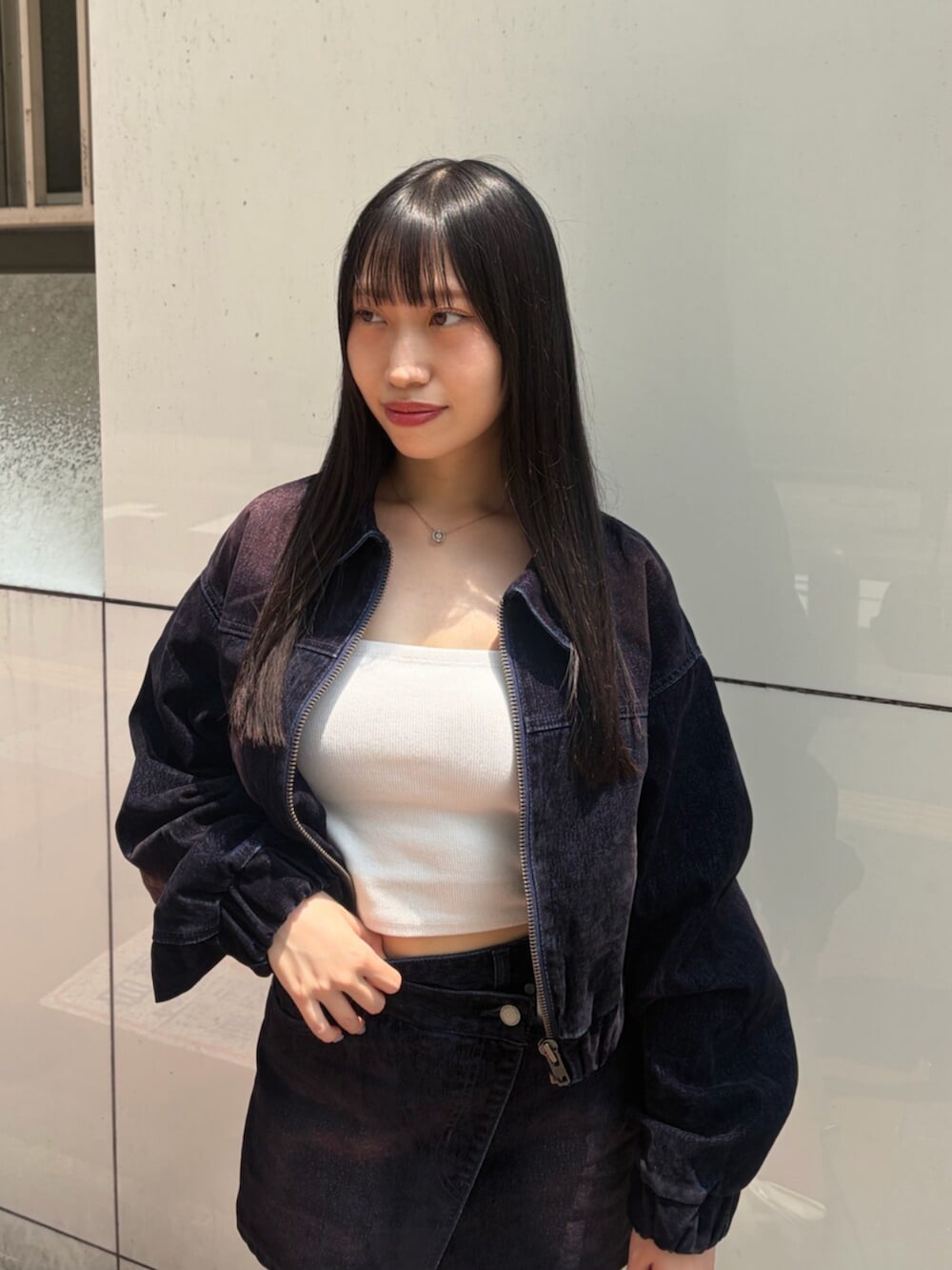 ホワイト系のキャミソール、ブラック系のスニーカー、ブルー系のブルゾンを着用したレディースの夏コーディネートの4枚目の写真