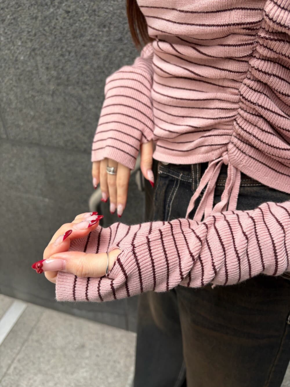 ブラック系のブーツ、ブルー系のデニムパンツ、ピンク系のニット/セーターを着用したレディースの冬コーディネートの6枚目の写真