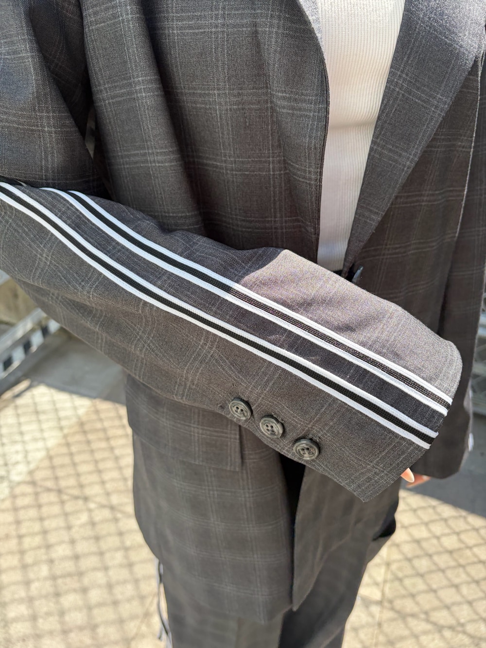 ホワイト系のスニーカー、グレー系のテーラードジャケット、グレー系のその他パンツを着用したレディースの春コーディネートの6枚目の写真