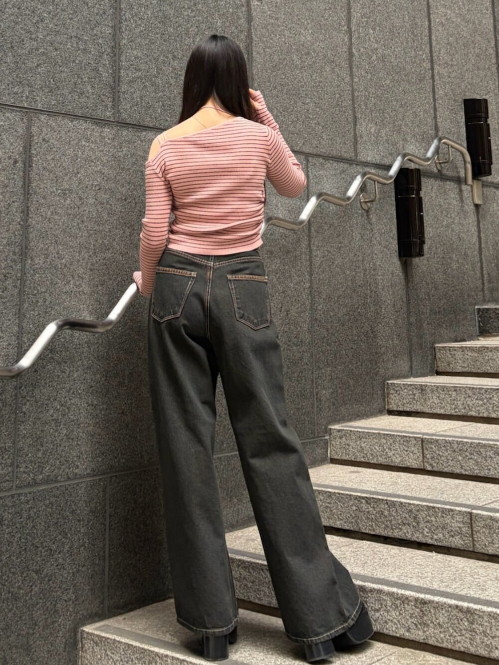 ブラック系のブーツ、ブルー系のデニムパンツ、ピンク系のニット/セーターを着用したレディースの冬コーディネートの3枚目の写真