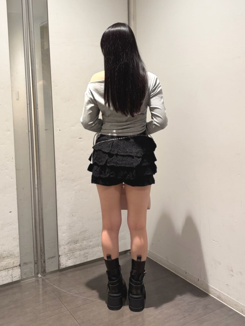 ブラック系のブーツ、グレー系のTシャツ/カットソー、ブラック系のスカートを着用したレディースの夏コーディネートの3枚目の写真