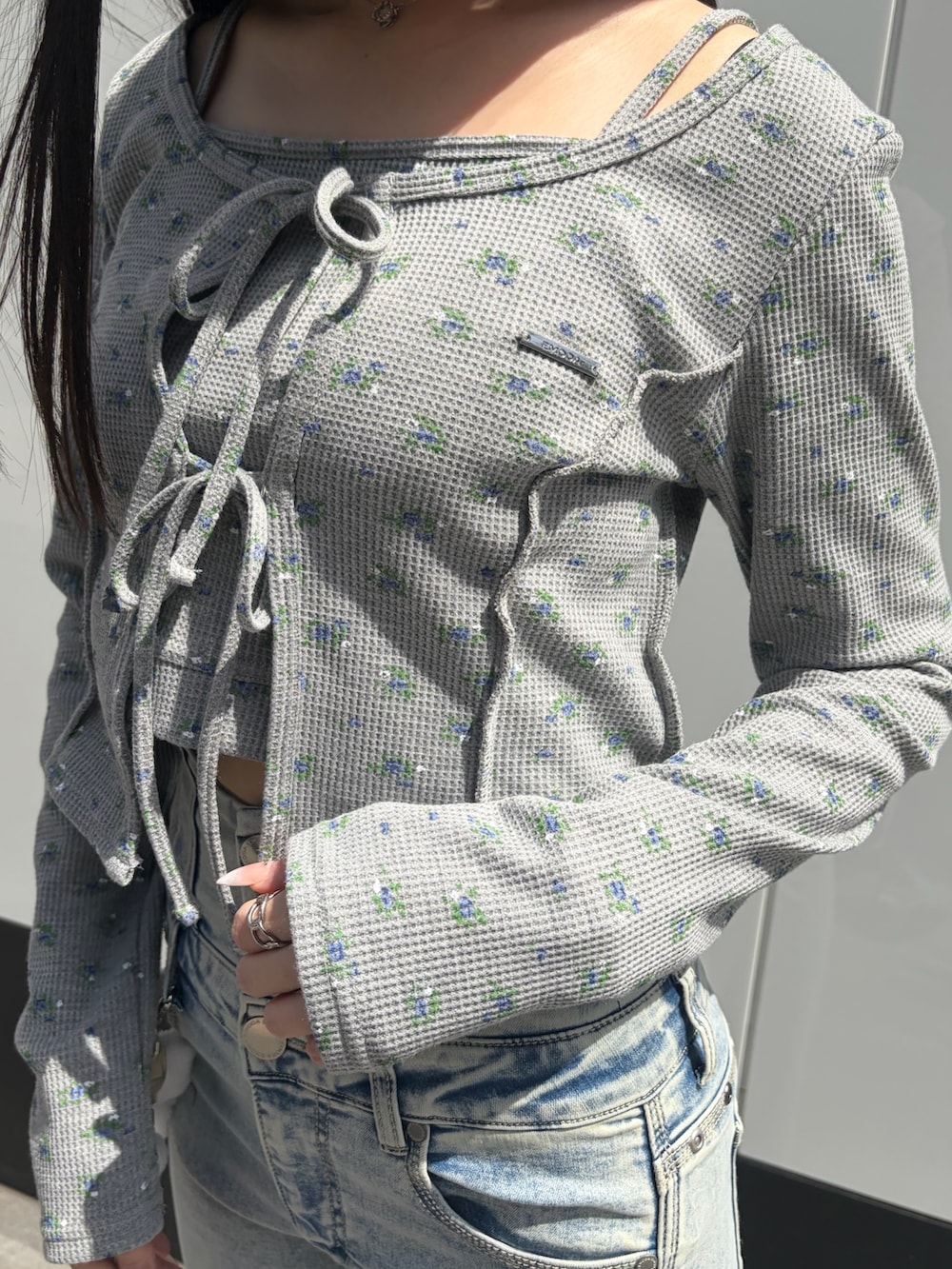 グレー系のTシャツ/カットソー、ブルー系のデニムパンツ、ブラック系のサンダルを着用したレディースの春コーディネートの5枚目の写真