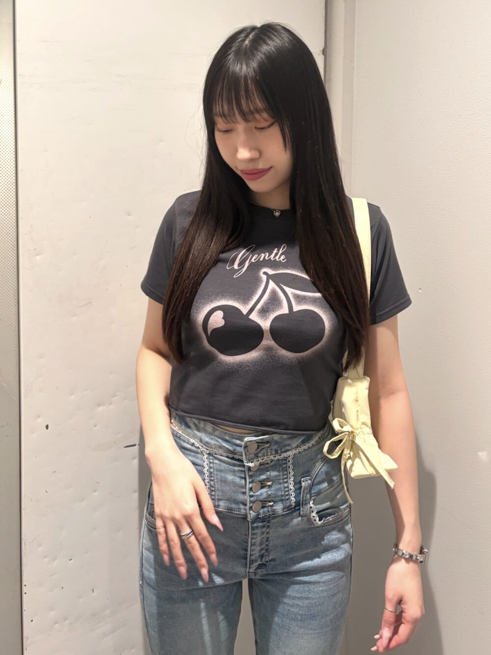 ブラック系のサンダル、グレー系のTシャツ/カットソー、イエロー系のハンドバッグを着用したレディースの春コーディネートの4枚目の写真