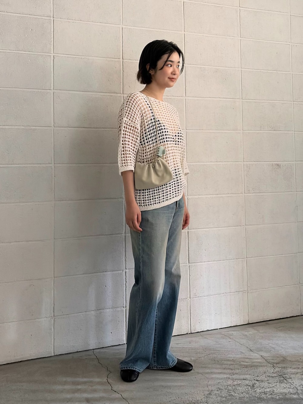 ブルー系のデニムパンツ、ホワイト系のニット/セーターを着用したレディースの春コーディネートの2枚目の写真