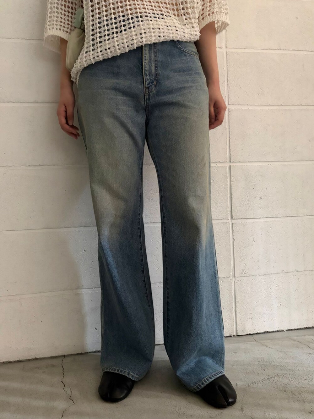 ブルー系のデニムパンツ、ホワイト系のニット/セーターを着用したレディースの春コーディネートの4枚目の写真