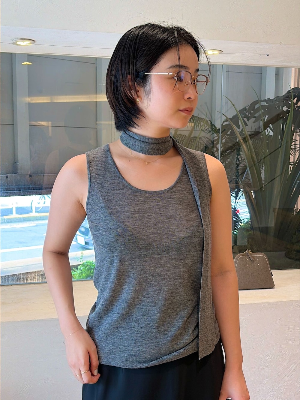 ブラック系のスカート、グレー系のニット/セーターを着用したレディースの夏コーディネートの3枚目の写真
