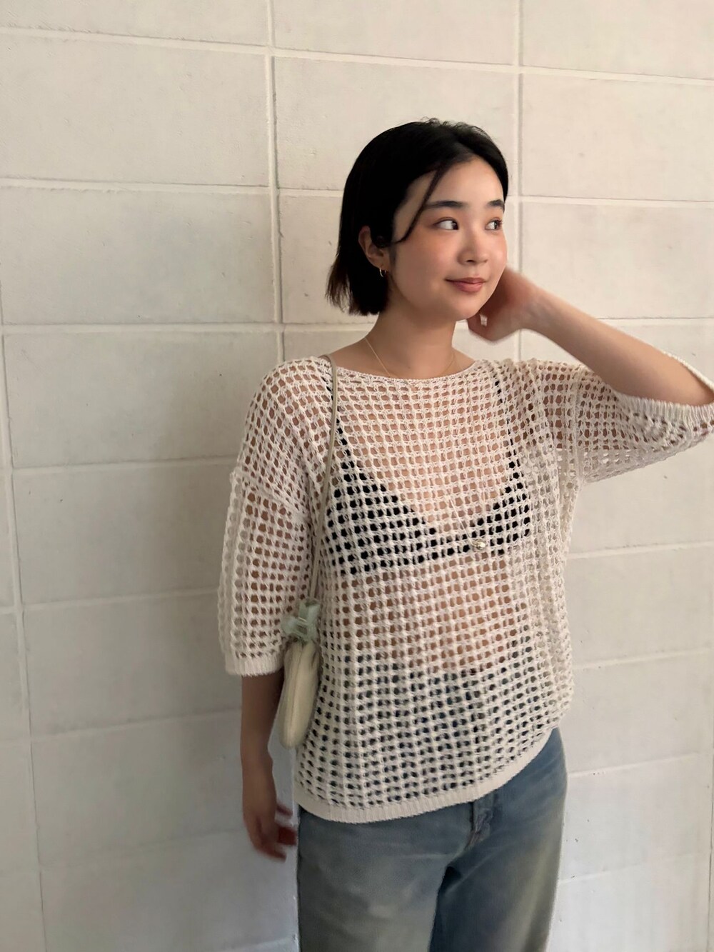 ブルー系のデニムパンツ、ホワイト系のニット/セーターを着用したレディースの春コーディネートの3枚目の写真