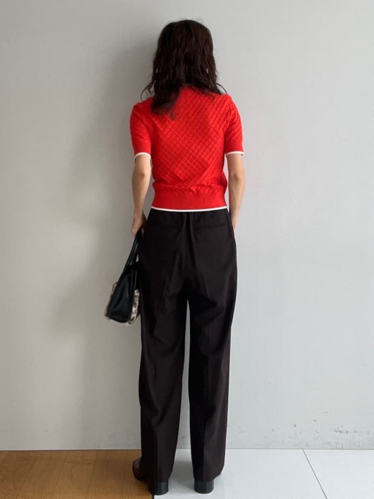 オレンジ系のニット/セーター、ブラウン系のその他パンツ、ベージュ系のトートバッグを着用したレディースの秋コーディネートの3枚目の写真