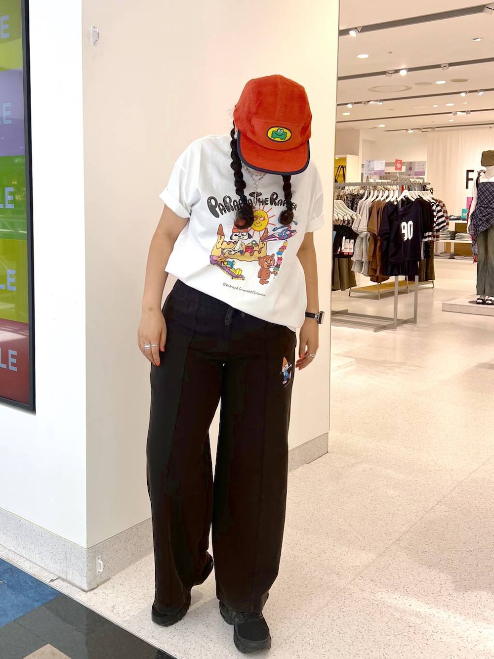 ホワイト系のTシャツ/カットソー、ブラック系のスウェットパンツ、オレンジ系のキャップを着用したレディースの夏コーディネートの2枚目の写真