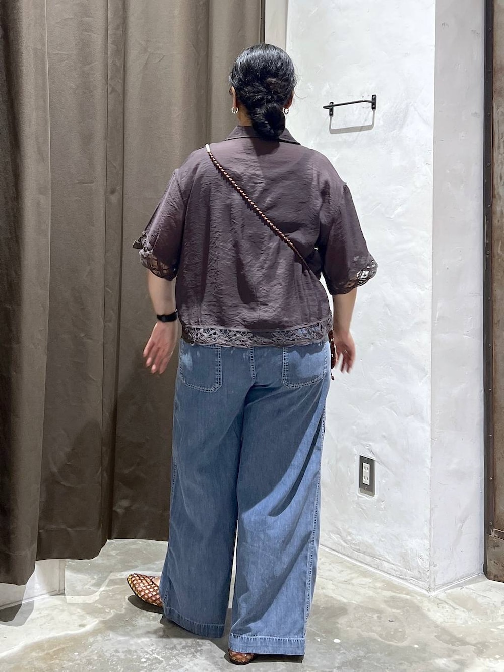 ブラウン系のパンプス、ブラウン系のショルダーバッグ、ブルー系のデニムパンツを着用したレディースの夏コーディネートの2枚目の写真