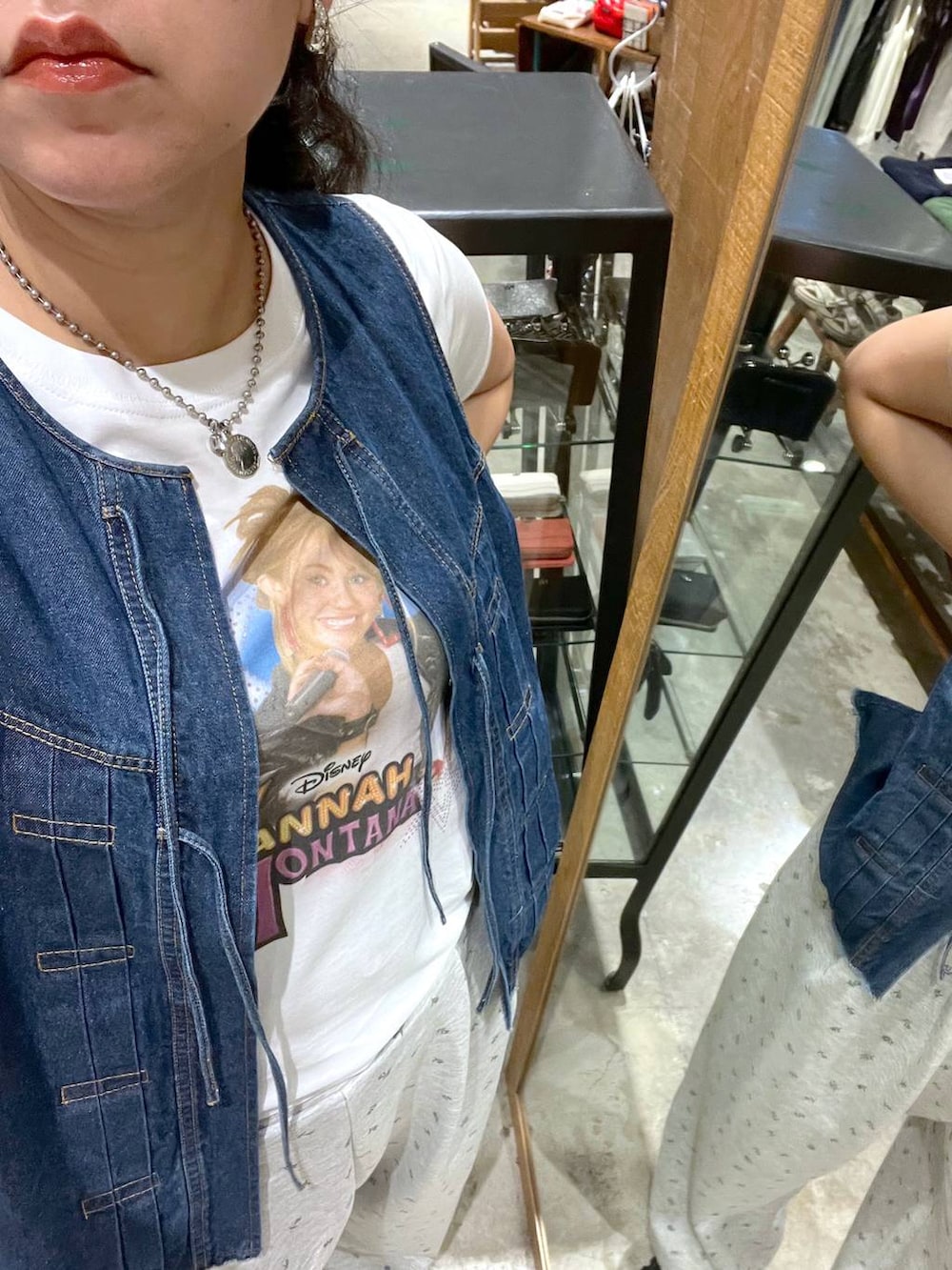 ブルー系のベスト、ブラック系のスニーカー、ホワイト系のTシャツ/カットソーを着用したレディースの夏コーディネートの2枚目の写真