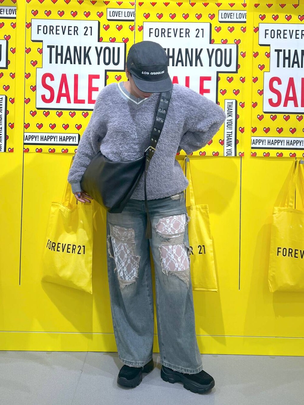 グレー系のニット/セーター、ブルー系のデニムパンツ、ブラック系のモカシン/デッキシューズを着用したレディースの秋コーディネートの2枚目の写真