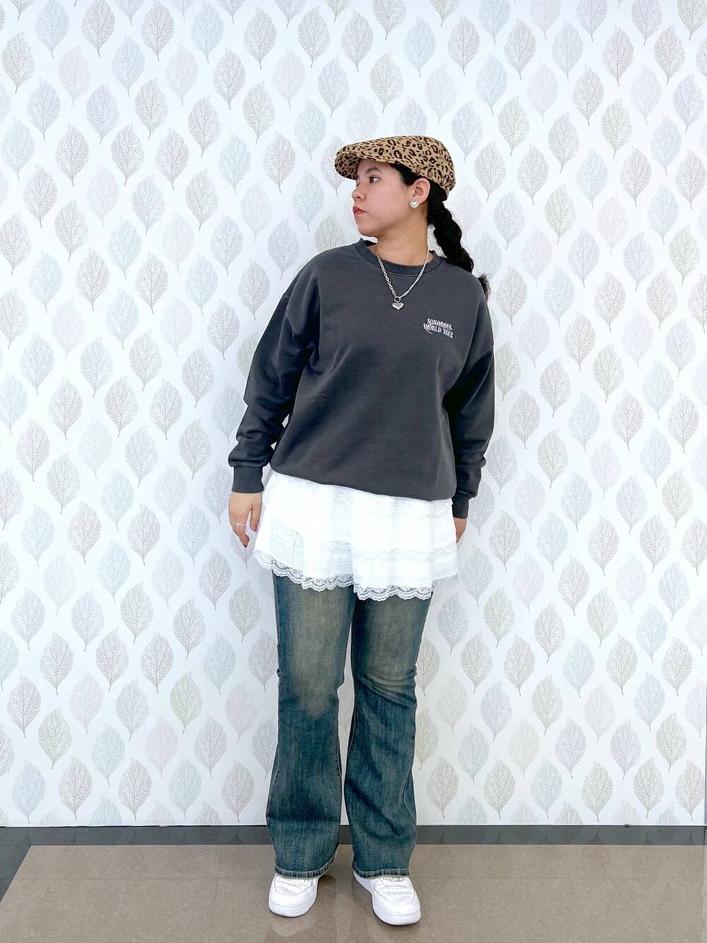 ブルー系のデニムパンツ、グレー系のスウェット、ホワイト系のスカートを着用したレディースの春コーディネートの3枚目の写真