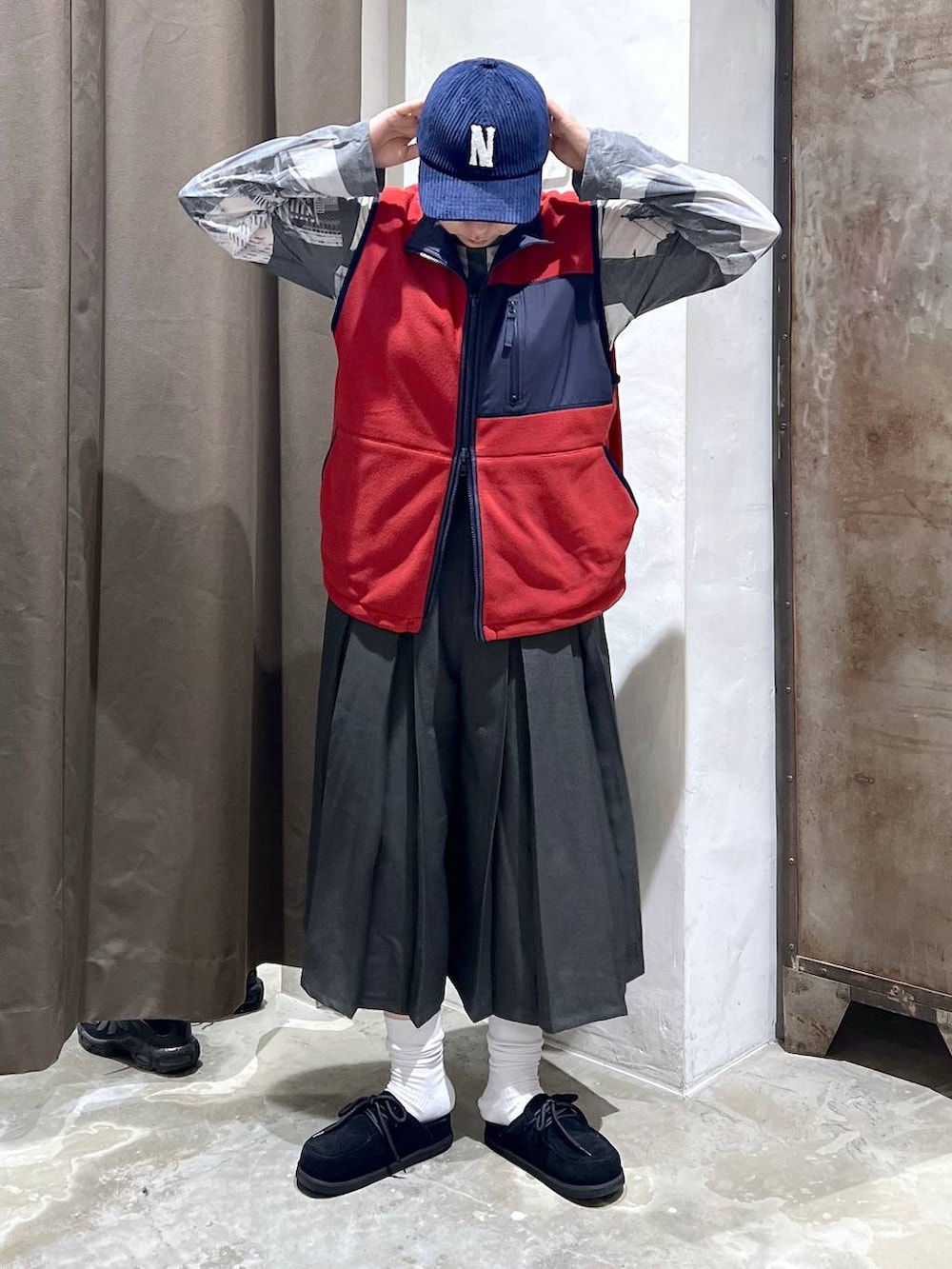 ブラック系のモカシン/デッキシューズ、レッド系のベスト、グレー系のその他パンツを着用したレディースの秋コーディネートの2枚目の写真