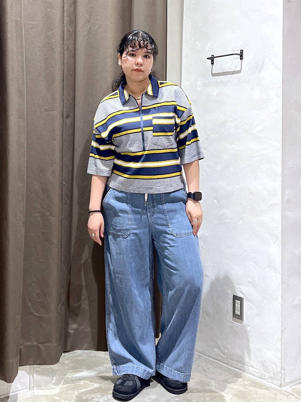 ブラック系のスニーカー、ブルー系のTシャツ/カットソー、ブルー系のデニムパンツを着用したレディースの夏コーディネートの3枚目の写真