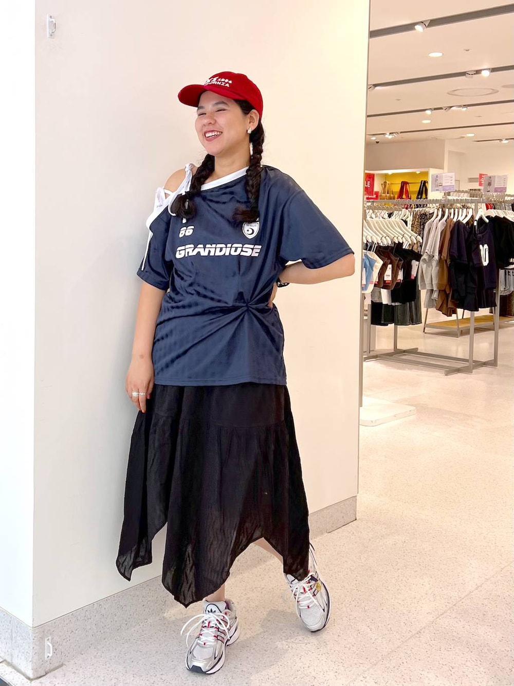 ブルー系のワンピース、ブラック系のスカート、レッド系のキャップを着用したレディースの夏コーディネートの4枚目の写真