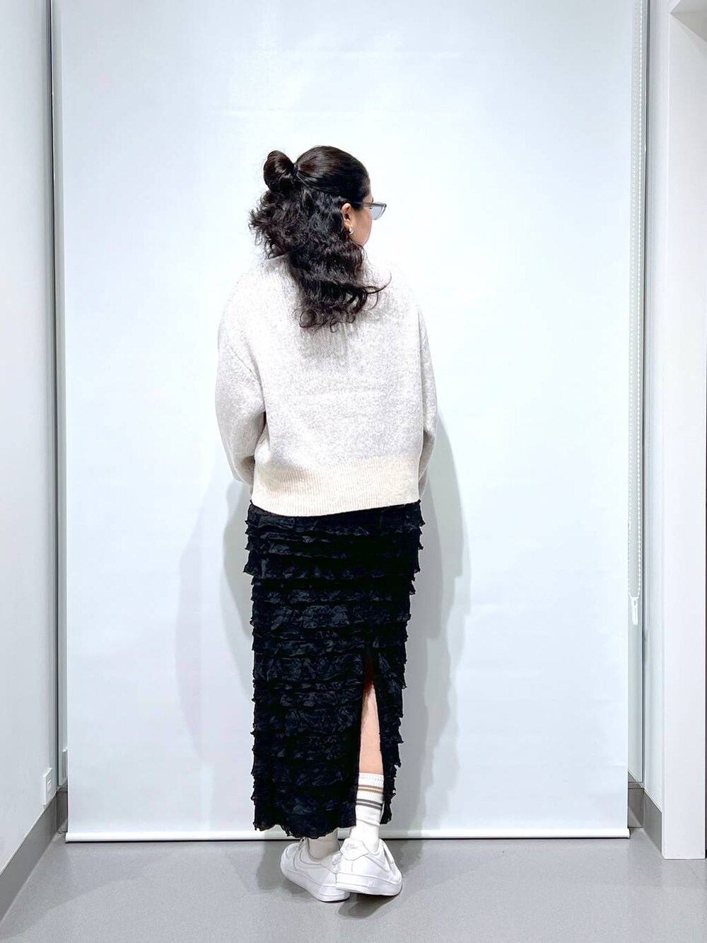 ホワイト系のニット/セーター、ブラック系のスカートを着用したレディースの秋コーディネートの2枚目の写真