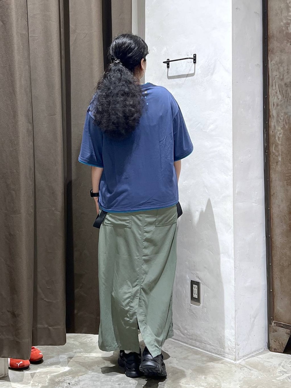 ブラック系のスニーカー、グリーン系のジャンパースカート、ブルー系のTシャツ/カットソーを着用したレディースの夏コーディネートの2枚目の写真