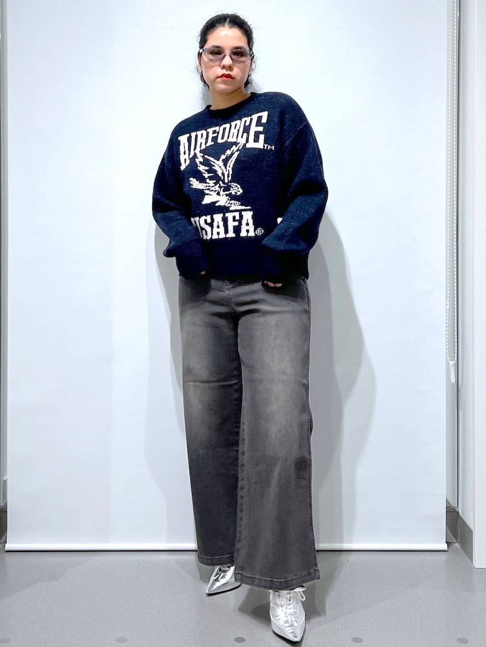 ブラック系のデニムパンツ、シルバー系のパンプス、ブルー系のニット/セーターを着用したレディースの秋コーディネートの2枚目の写真