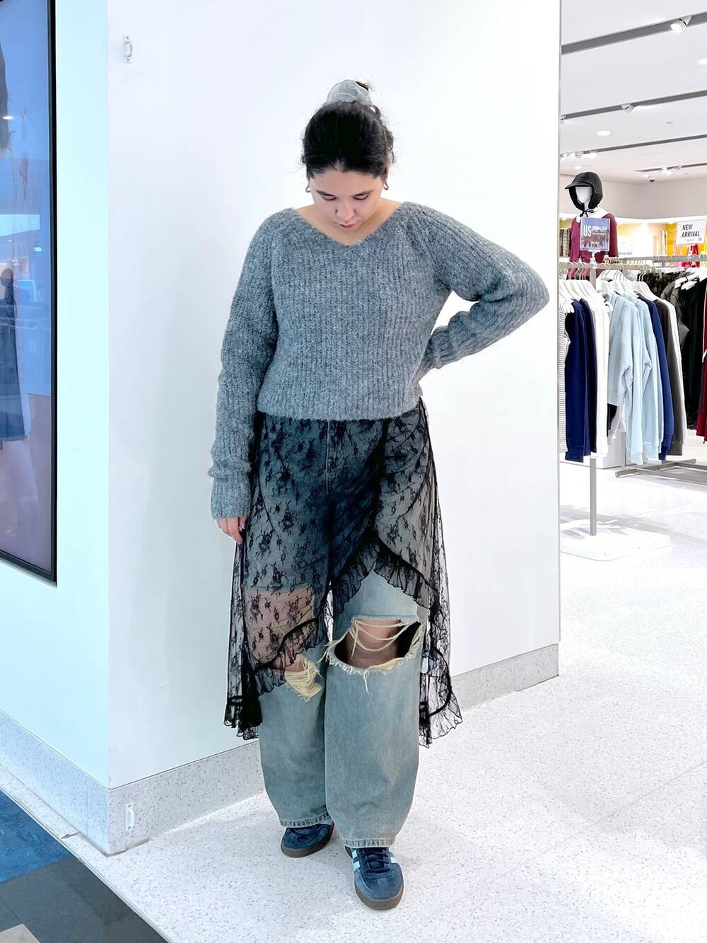 ブルー系のデニムパンツ、ブラック系のワンピース、グレー系のカーディガン/ボレロを着用したレディースの秋コーディネートの2枚目の写真