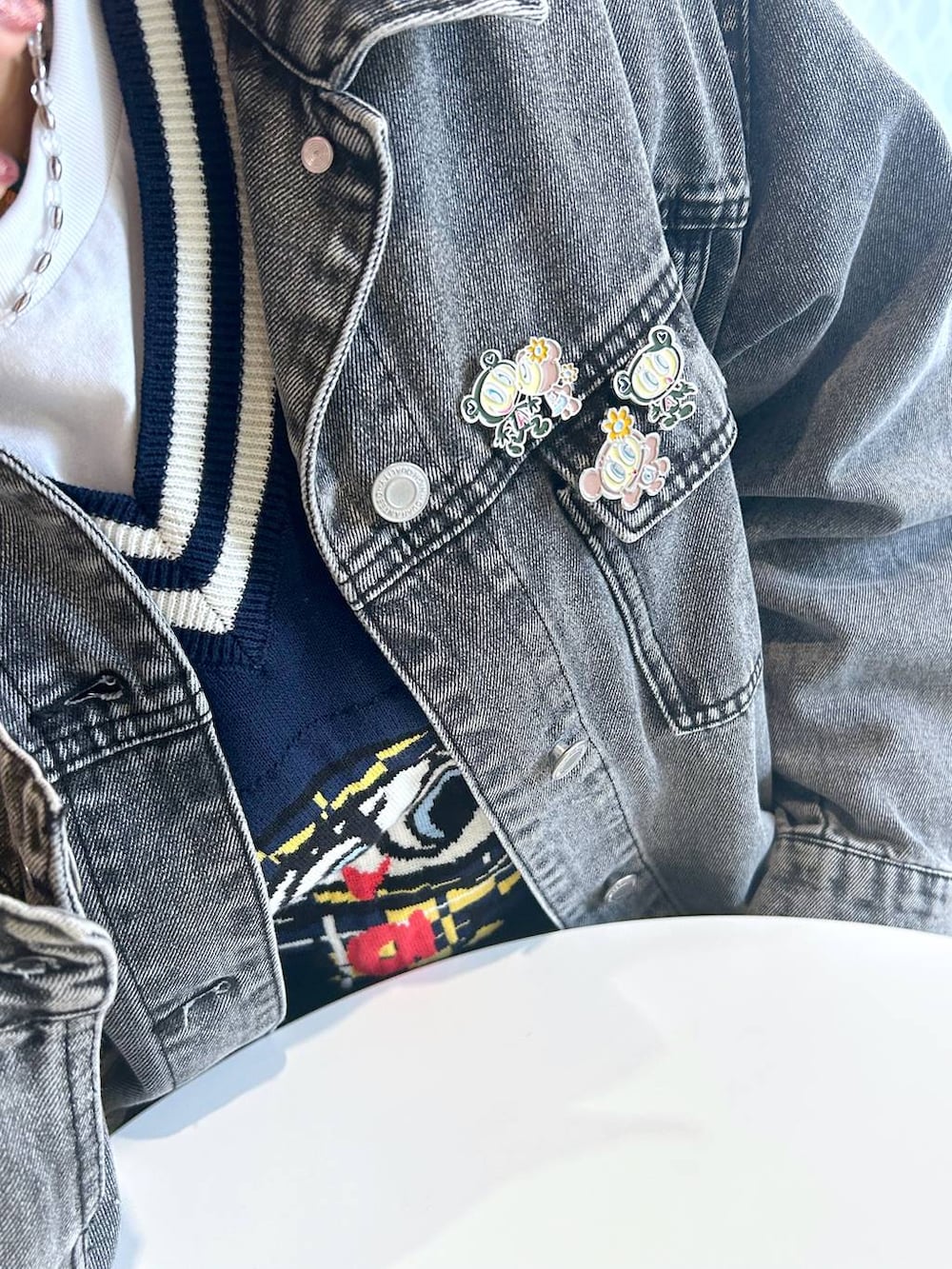 グレー系のデニムジャケット、ブルー系のベスト、イエロー系のトートバッグを着用したレディースの春コーディネートの2枚目の写真