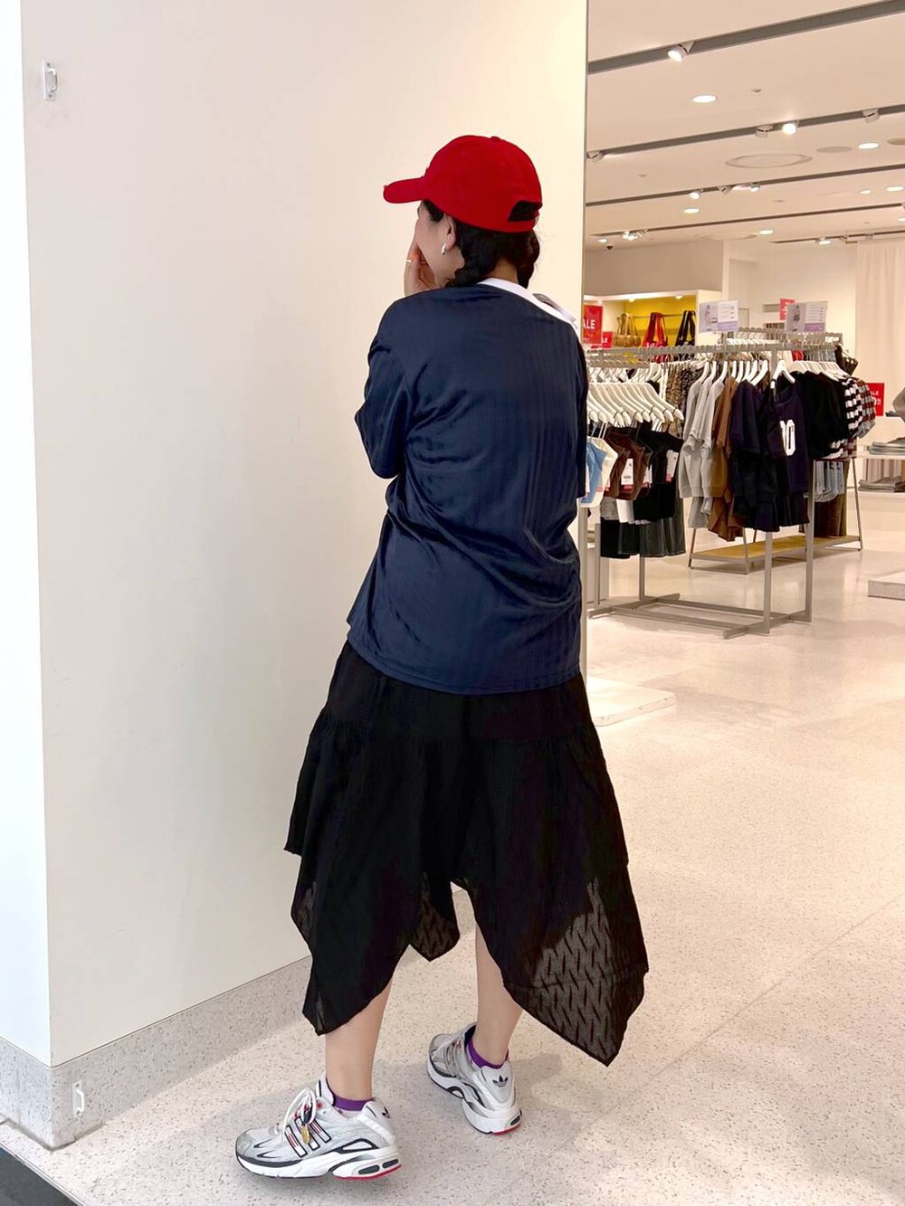 ブルー系のワンピース、ブラック系のスカート、レッド系のキャップを着用したレディースの夏コーディネートの3枚目の写真