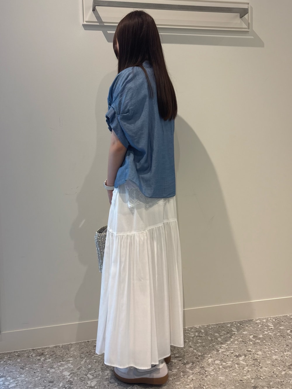 ホワイト系のスカート、ブルー系のシャツ/ブラウス、ホワイト系のTシャツ/カットソーを着用したレディースの春コーディネートの2枚目の写真