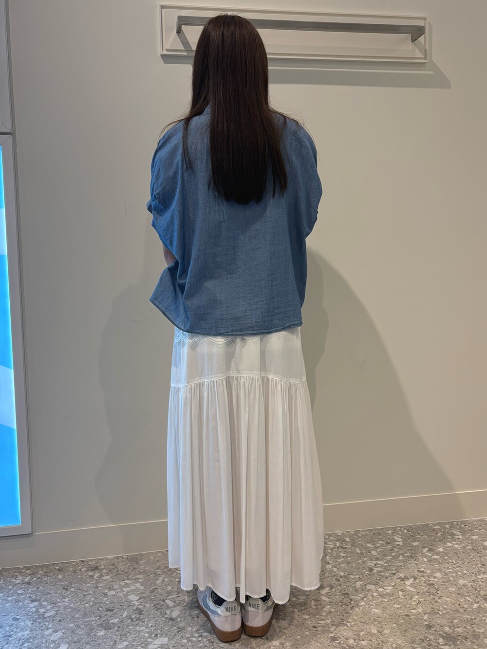 ホワイト系のスカート、ブルー系のシャツ/ブラウス、ホワイト系のTシャツ/カットソーを着用したレディースの春コーディネートの5枚目の写真