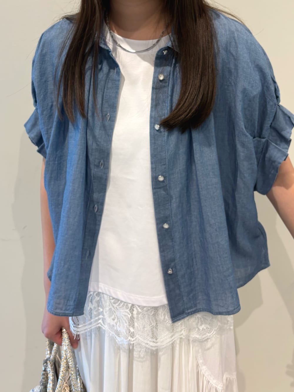 ホワイト系のスカート、ブルー系のシャツ/ブラウス、ホワイト系のTシャツ/カットソーを着用したレディースの春コーディネートの7枚目の写真