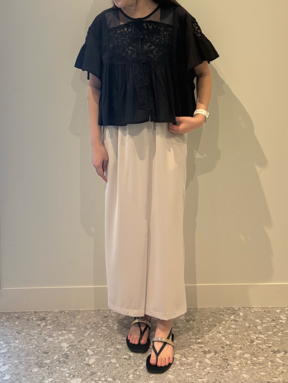 ブラック系のシャツ/ブラウス、ベージュ系のスカート、ブラック系のサンダルを着用したレディースの夏コーディネートの4枚目の写真