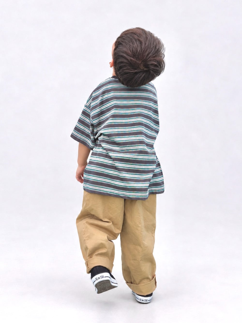 ベージュ系のチノパンツ、ブラック系のスニーカー、グレー系のTシャツ/カットソーを着用したキッズの秋コーディネートの2枚目の写真