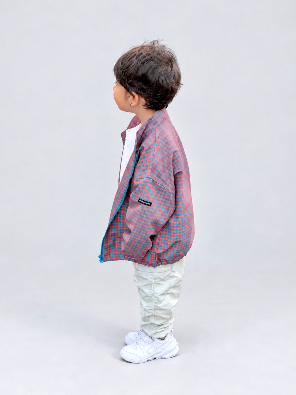 ホワイト系のスニーカー、オレンジ系のブルゾン、ホワイト系のTシャツ/カットソーを着用したキッズの秋コーディネートの2枚目の写真