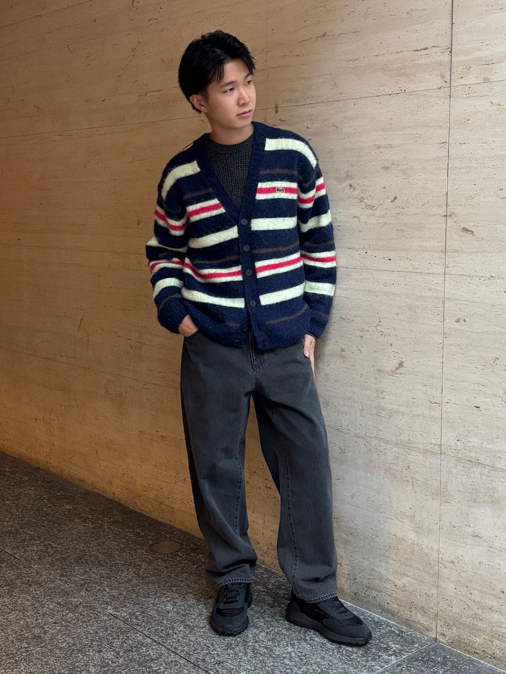 ブラック系のダウンベスト、ブルー系のカーディガン/ボレロ、ブラック系のデニムパンツを着用したメンズの冬コーディネートの5枚目の写真