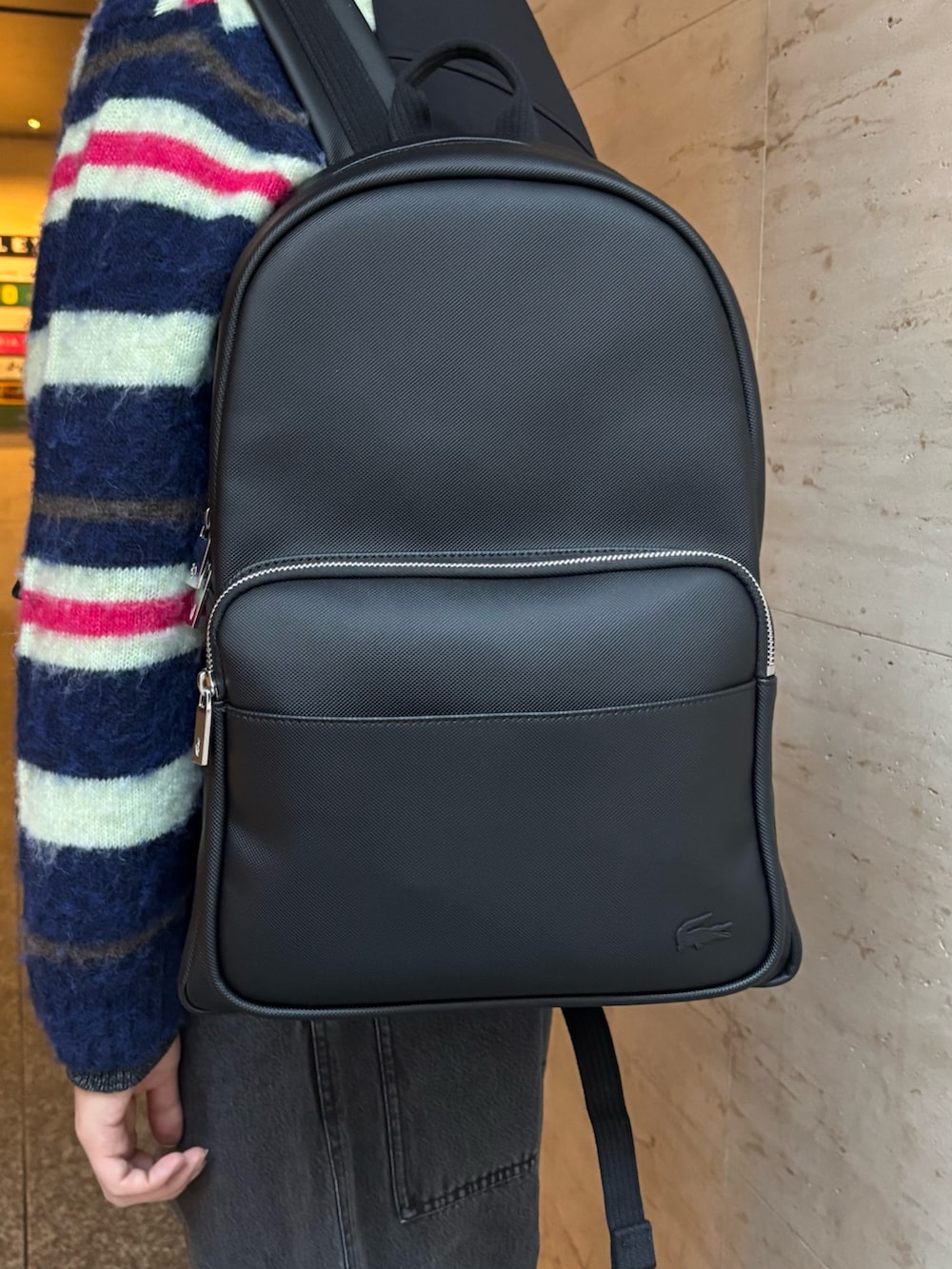 ブラック系のダウンベスト、ブルー系のカーディガン/ボレロ、ブラック系のデニムパンツを着用したメンズの冬コーディネートの6枚目の写真