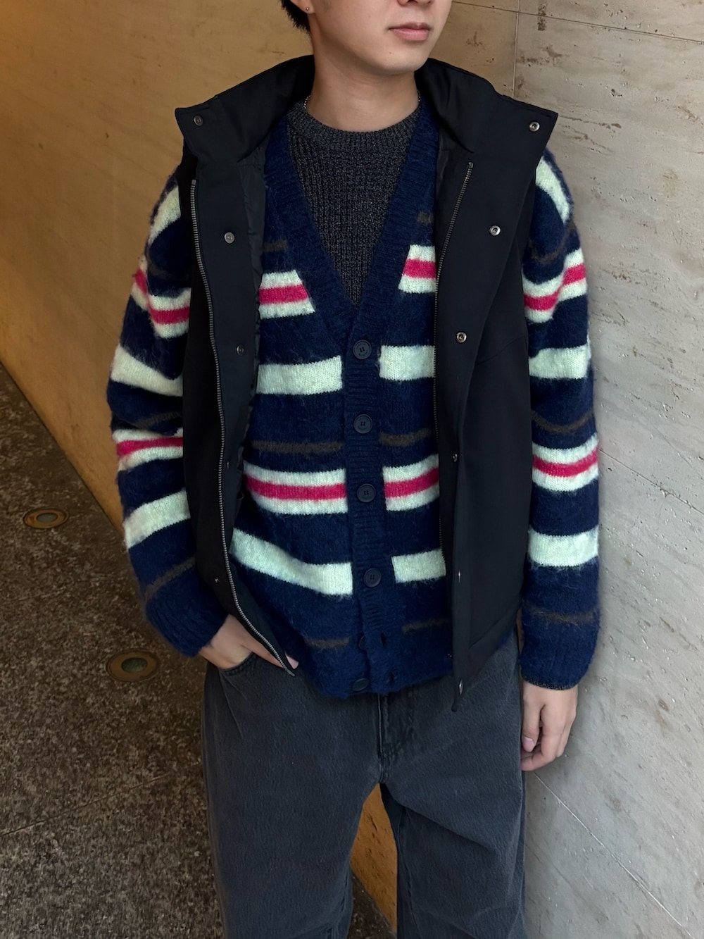 ブラック系のダウンベスト、ブルー系のカーディガン/ボレロ、ブラック系のデニムパンツを着用したメンズの冬コーディネートの4枚目の写真