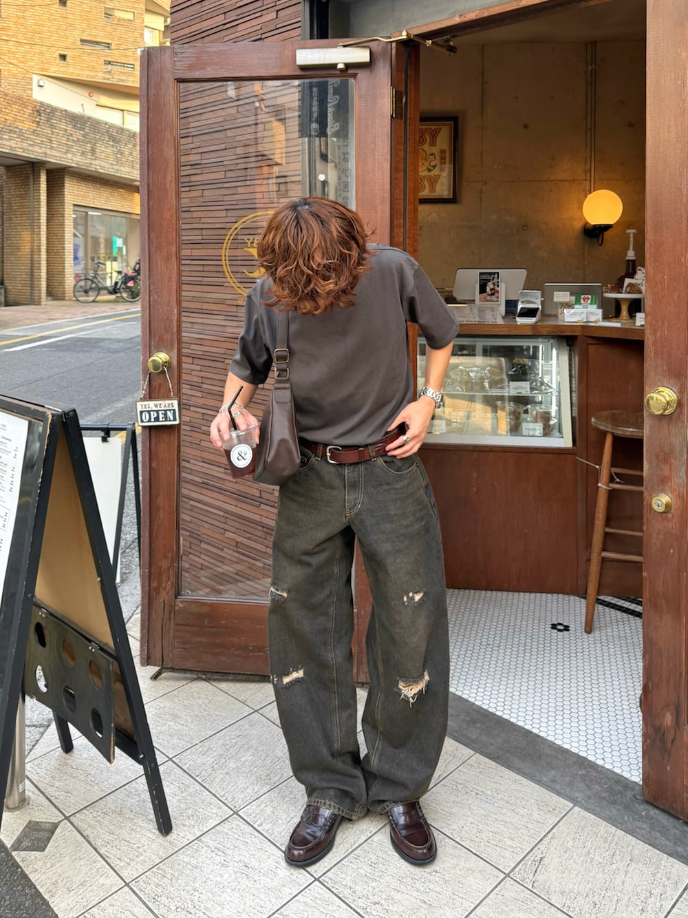 グレー系のTシャツ/カットソー、ブラック系のデニムパンツ、ブラウン系のショルダーバッグを着用したメンズの夏コーディネートの2枚目の写真
