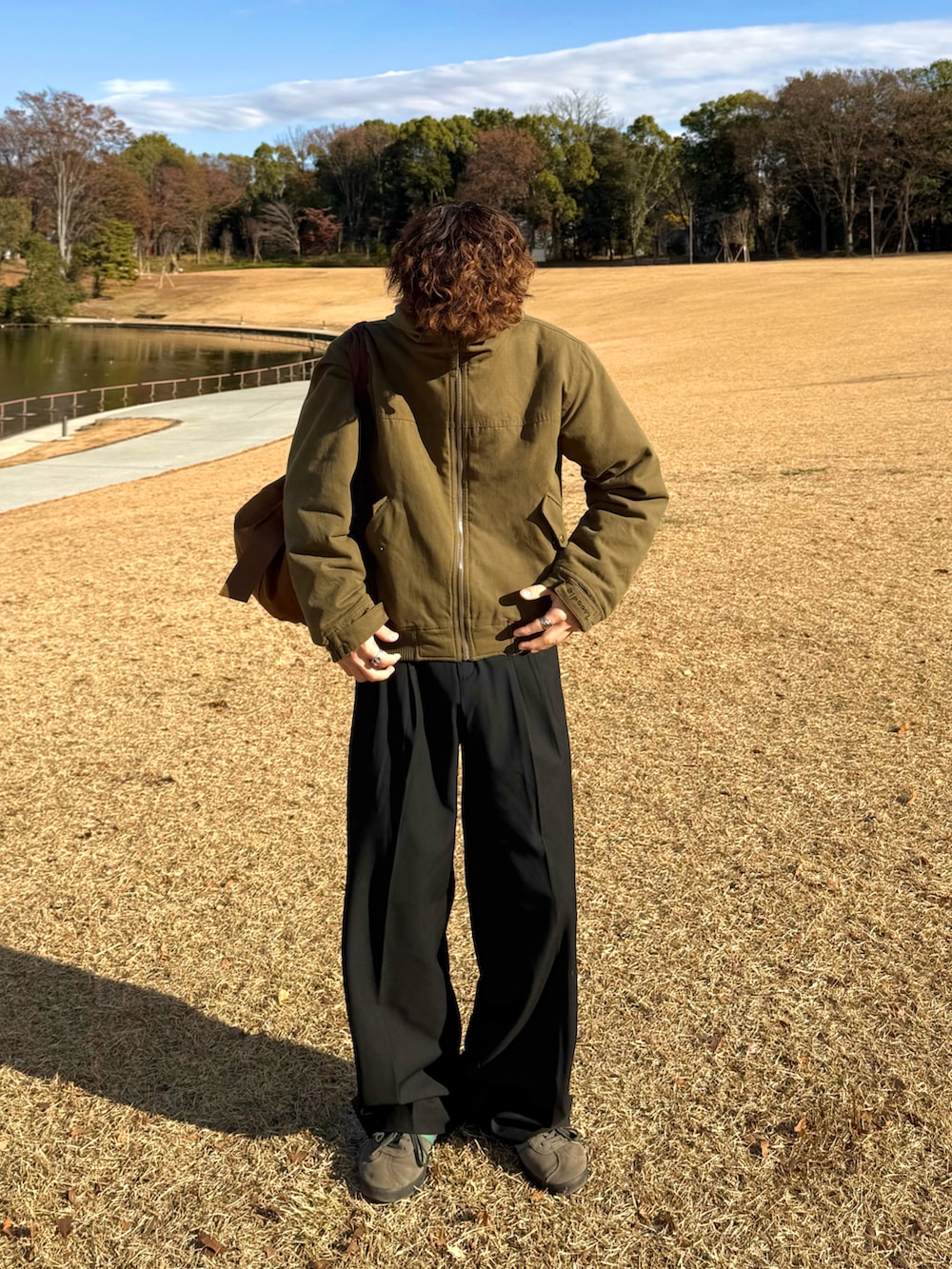 ブラウン系のニット/セーター、グリーン系のその他アウター、ブラウン系のトートバッグを着用したメンズの冬コーディネートの2枚目の写真